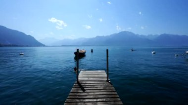 Arka planda dağlar olan güzel, el değmemiş İsviçre gölü. Montreux İsviçre 'nin doğal ortamında ahşap iskele.