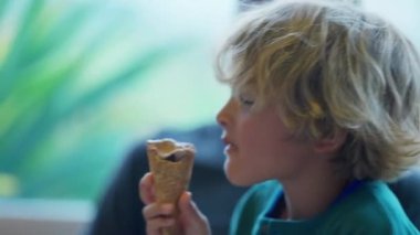 Küçük sevimli çocuk çikolatalı dondurma yiyor. Otantik çocuk atıştırmalık yiyor.