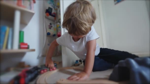 孩子在房间里玩 一个小孩一个人玩玩具 小男孩儿在卧室的地板上 有铁轨 — 图库视频影像