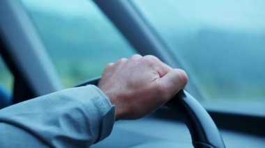 Direksiyonda direksiyona yakın el. Erkek sürücü.