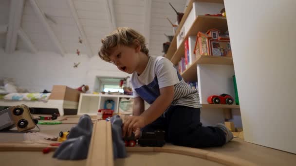 可爱的孩子在卧室里玩火车 一个小男孩在玩木制火车 儿童发展概念 — 图库视频影像