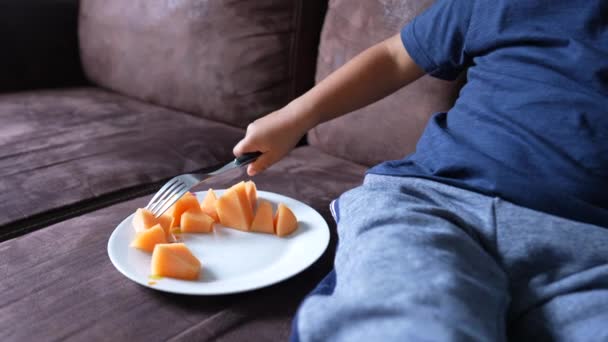 Kind Isst Melonenfrüchte Auf Dem Sofa Hause Kind Isst Gesundes — Stockvideo
