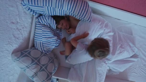 两个可爱的弟弟躺在床上 玩耍的兄弟姐妹们在晨报上玩得很开心 快乐的家庭成员关系 — 图库视频影像
