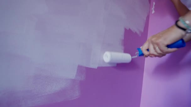 Mulher Pintura Parede Roxa Com Cor Branca Usando Rolo Pintura — Vídeo de Stock