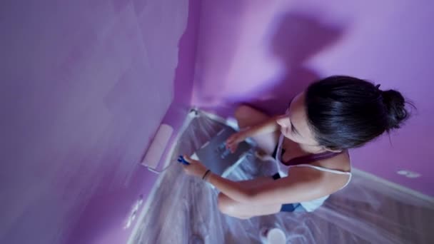 Mujer Pintando Pared Púrpura Con Color Blanco Usando Rodillo Pintura — Vídeo de stock