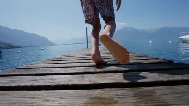 Мальчик Бежит Прыгает Воду Озера Низкоугольный Снимок Ребенка Бежит Причале — стоковое видео