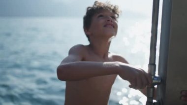 Genç bir çocuk sahildeki duşta cesedi yıkıyor. Genç erkek çocuk yavaş çekimde ferahlatıcı su altında