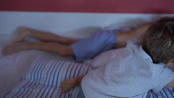 幼児の弟の兄とベッドにジャンプします 二人の兄弟は週末を一緒にベッドの下で — ストック動画