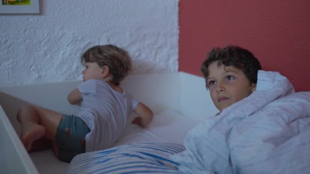 两个兄弟在早上的床上 周末躺在床单上的真实的亲生兄弟姐妹 — 图库视频影像