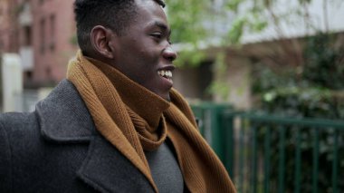 Siyahi adam başarıyı kutluyor. Havaya yumruk atıyor. Başarılı bir Afrikalı 2nci şehirde yürüyor