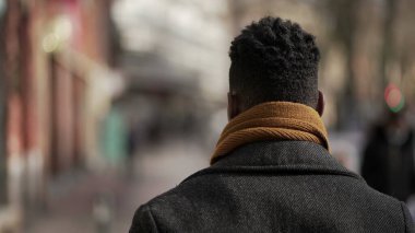 Back of black man walking outside in city