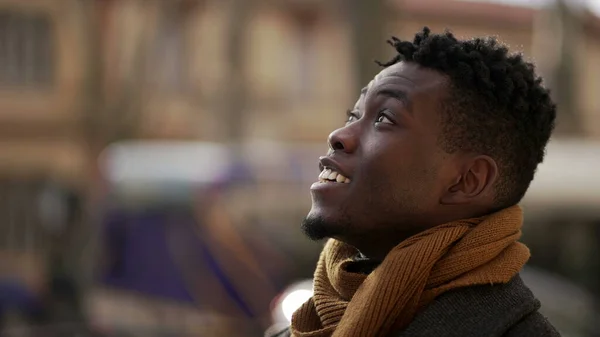 Black man looking at sky smiling with HOPE and FAITH