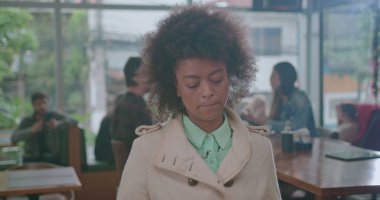 Kafede kuyrukta bekleyen dalgın bir zenci kadın. Afro-Amerikalı düşünceli bir bayan müşteri kafe restoranında dudaklarını ısırarak bekliyor.