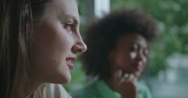 Sohbet eden iki mutlu kadın. Kapalı kafelerde konuşan kadın yüzleri fikir alışverişinde bulunuyor ve dedikodu yapıyorlar.