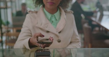 Cep telefonu kablosuz ödeme yöntemiyle sipariş veren genç bir kadın. Afro-Amerikalı kadın akıllı telefonu ürün satın almak için kullanıyor.