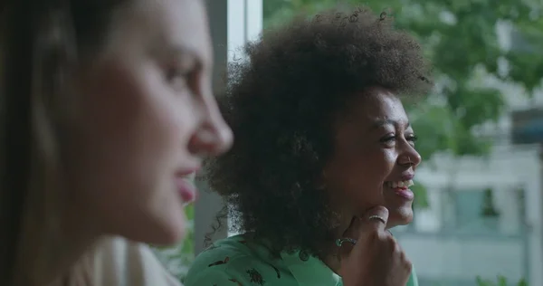 stock image Two happy diverse women speaking in conversation. Closeup female faces talking at coffee shop exchanging ideas and gossip