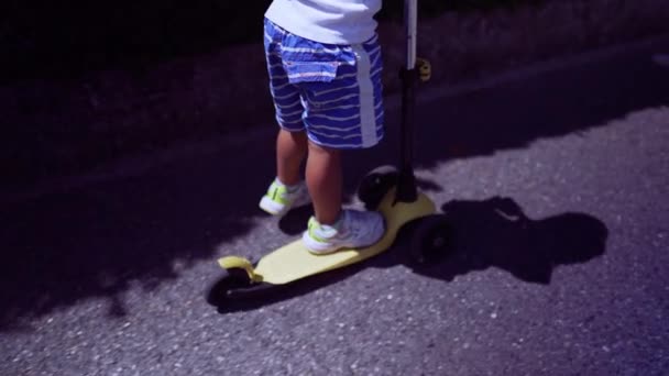 城市街道上 男孩的腿骑着3轮滑板车 儿童游乐玩具 — 图库视频影像
