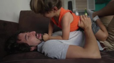 Baba küçük oğlu evdeki kanepede yatıyor. Otantik gerçek ebeveyn ve çocuk samimi bir an