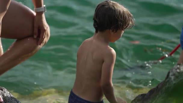 Ένα Ειλικρινές Παιδί Δίπλα Στη Λίμνη Την Οικογένειά Του Πίσω — Αρχείο Βίντεο