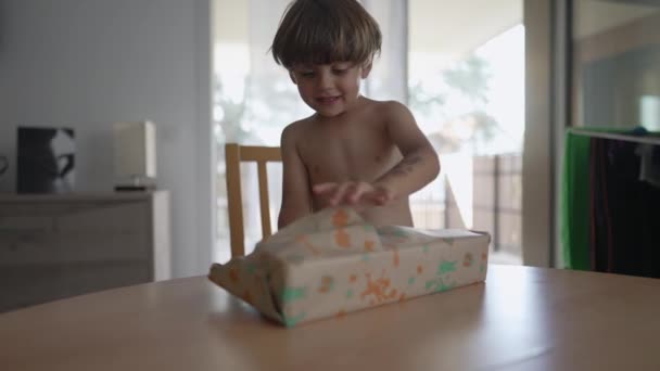 快乐的孩子打开礼物 小男孩打开生日礼物的包装 — 图库视频影像