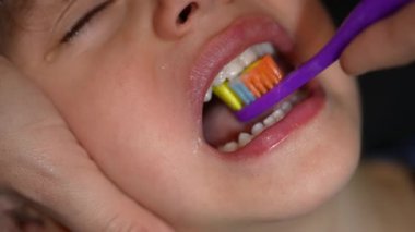 Ebeveyn fırçalayan çocuk ağzı makro yakın plan. Diş hijyenine bakıyorum. Uyku zamanı gece rutini