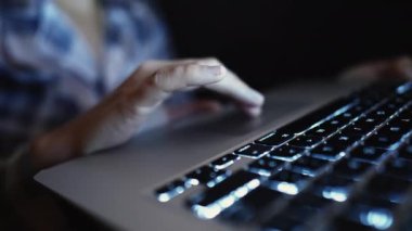 Akşamları pist bilgisayarı kullanan kadın eli. Bilgisayarın önünde internette gezinen kişi