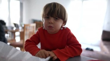 Kameraya tüküren yaramaz küçük çocuk. Yaramaz çocuk uslu durmuyor ve gülümsüyor.