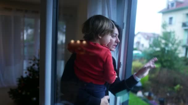 母親は腕の中で幼児を保持し アパートの窓をロック 窓の外を見て閉じる女 — ストック動画