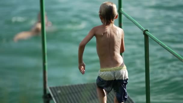 Ребенок Погружается Озерную Воду Ребенок Веселится Бегая Причале Прыгает Реку — стоковое видео