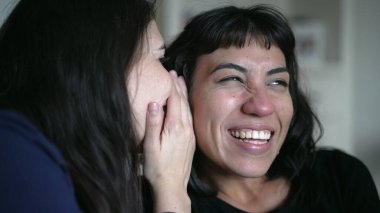 Friends sharing gossip whispering secret to woman ear telling SHOCKING news revelation. Two women sharing information