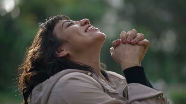 Religious thankful young woman raising arms in air celebrating life in prayer to God. Spiritual person feeling HOPE and FAITH feeling FREE