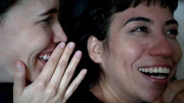 Women sharing rumor whispering SECRET to friend ear. Person reaction with SHOCK and UNBELIEF to NEWS