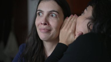 Friend telling secret to woman ear whispering. Young woman shock surprise reaction to gossip news. People sharing secrets