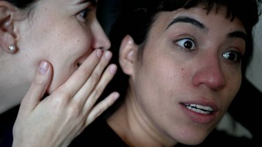 Women sharing rumor whispering SECRET to friend ear. Person reaction with SHOCK and UNBELIEF to NEWS
