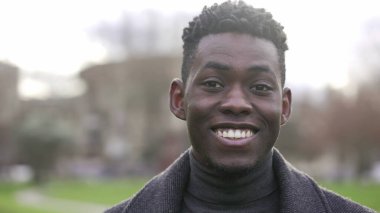 Handsome black African man smiling outside during daylight