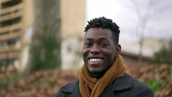 Happy black African man looking at camera smiling portrait during winter season
