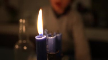 Çocuk mum ışığını yavaş çekimde üflüyor. Çocuk alev mumunu üflüyor. Dilek konsepti yapıyor 