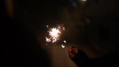 Yakın plan çocuk elinde maytap, yeni yıl arifesini kutluyor.