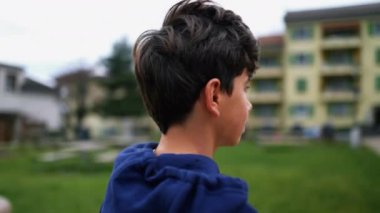 Şehir parkında genç bir çocuğun ciddi bir ifadeyle kameraya bakışını izliyorum. Metanetli erkek çocuk başını çeviriyor.