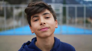 Parkta gülümseyen mutlu bir genç çocuk. Yakışıklı bir gencin portresi.