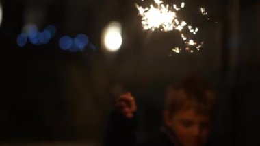 Bulanık çocuk elinde maytapla bayramları kutluyor.