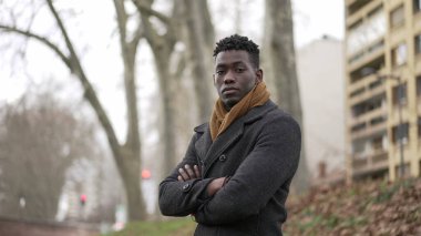 Confident African black man standing outside during winter season portrait staring camera