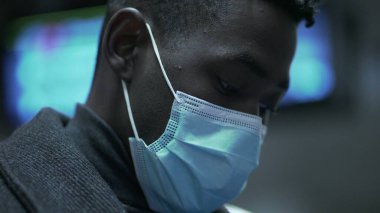 Siyah adam covid-19 yüz maskesi takıyor.