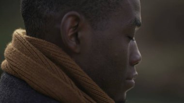 Meditative black man closing eyes in contemplation, close-up African person face