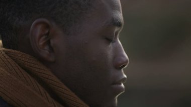Meditative black man closing eyes in contemplation, close-up African person face