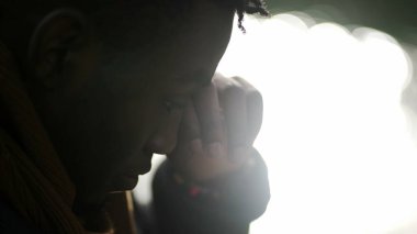 Man rubbing eyes with hands outside