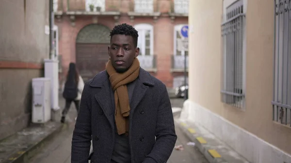 Moody pensive black african man walking in city