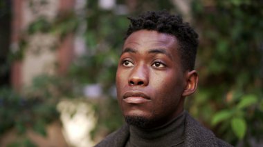 Pensive young black African man standing outdoors