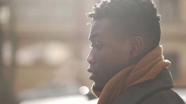 Pensive thoughtful black African man walking outside in winter season