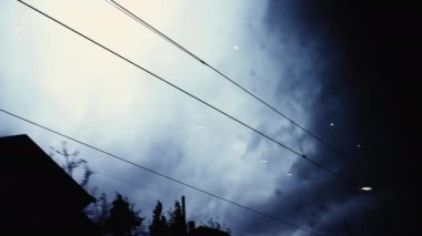 Pencere perspektifi ile seyahat ediyorum. Hüzünlü mavi günde hareket halindeki kablolara bakan yolcu portresi